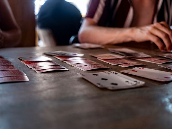 Playing cards laid out on a wooden table during a game.